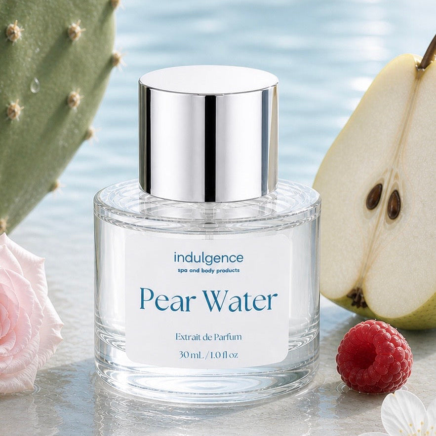 Perfume bottle labeled 'Pear Water' with a pear, raspberry, and flower on a reflective surface.