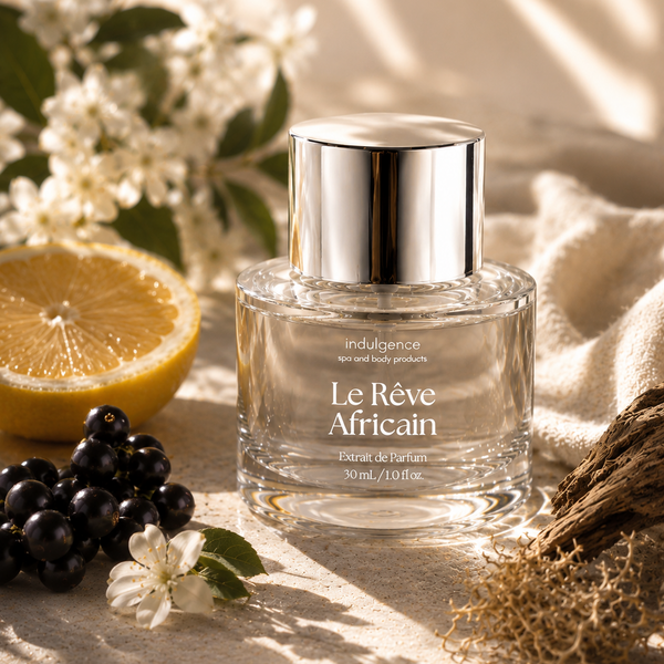 Perfume bottle labeled 'Le Reve Africain' with a lemon, grapes, and flowers on a textured surface.